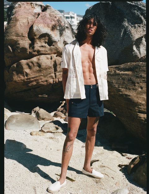 male model wearing shirt fully unbuttoned on the beach