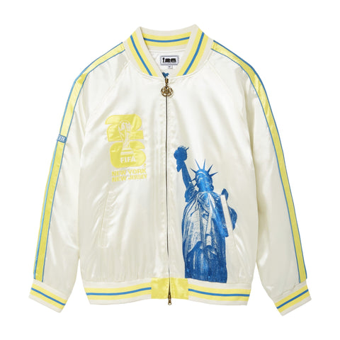 White satin bomber jacket with yellow and blue striped trim, FIFA World Cup 26 New York New Jersey artwork on the chest, a large blue Statue of Liberty graphic, shoulder stripes, side pockets, and a gold-tone two-way zipper.