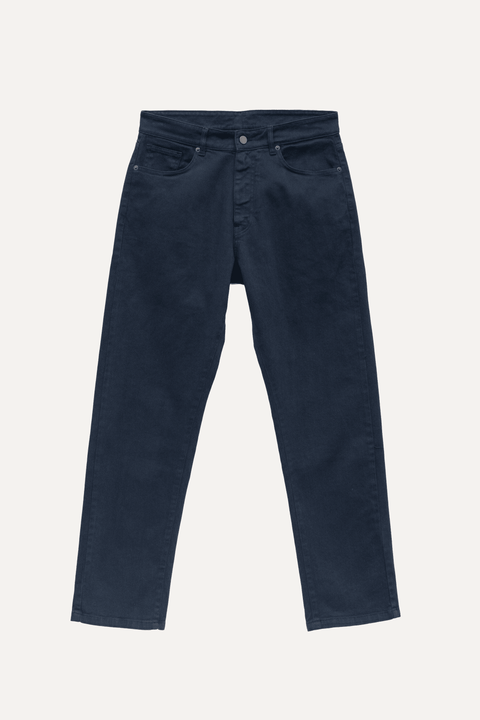A pair of navy jeans shown flat against a light off-white background - Inkerman NYC