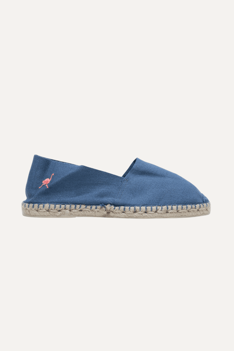 A single blue canvas espadrille slip-on shoe with a braided jute sole and a small pink flamingo logo on the side, shown against a light off-white background - Inkerman NYC