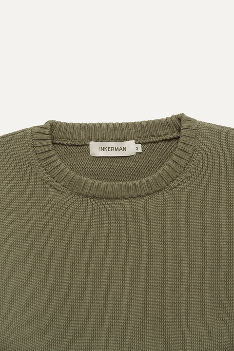 Close-up of a ribbed knit crewneck sweater in olive green - Inkerman NYC