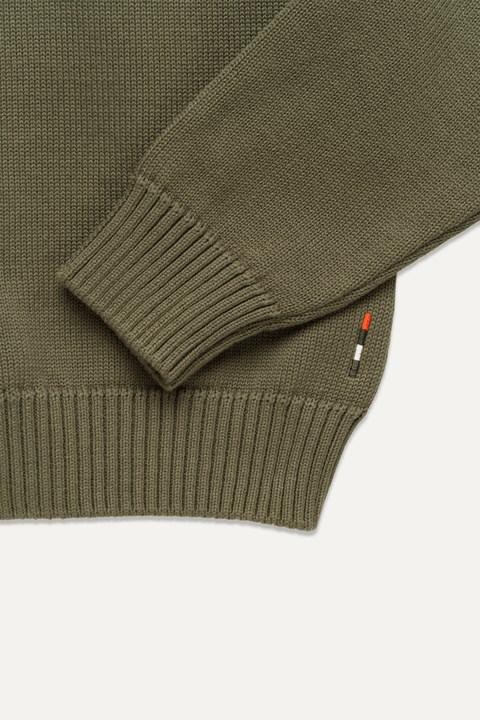 Close-up of an olive green knit sweater with ribbed cuffs and hem - Inkerman NYC