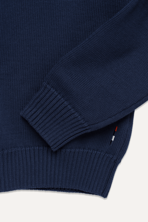 Close-up of a navy blue knit sweater showing the ribbed cuff and hem - Inkerman NYC