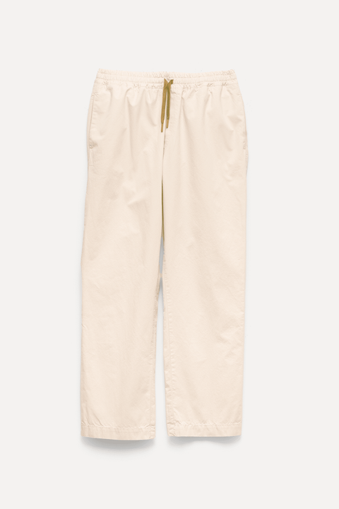 A pair of light beige wide-leg pants with an elastic waistband and a contrasting olive green drawstring, shown flat against a light off-white background - Inkerman NYC