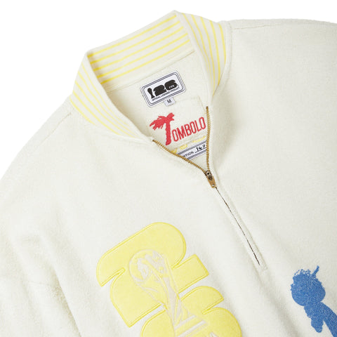 Close-up of a cream-colored jacket with embroidered designs and a visible brand label.