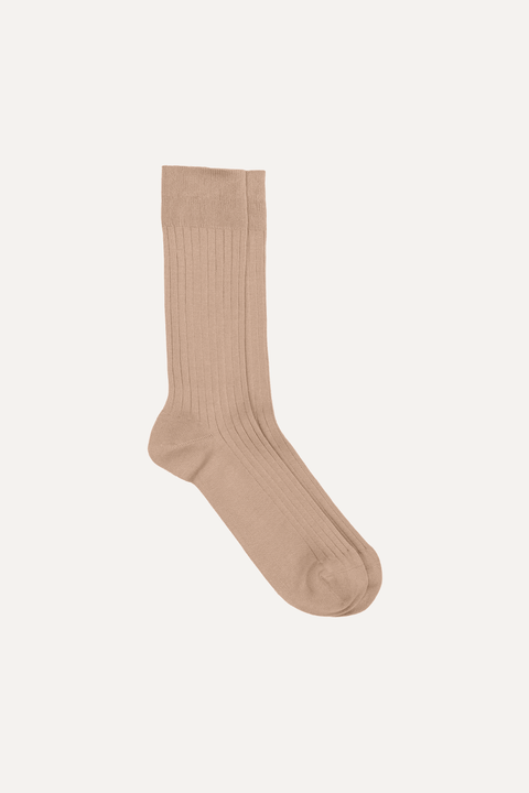 A single ribbed crew sock in a beige color, shown against a solid off-white background - Inkerman NYC