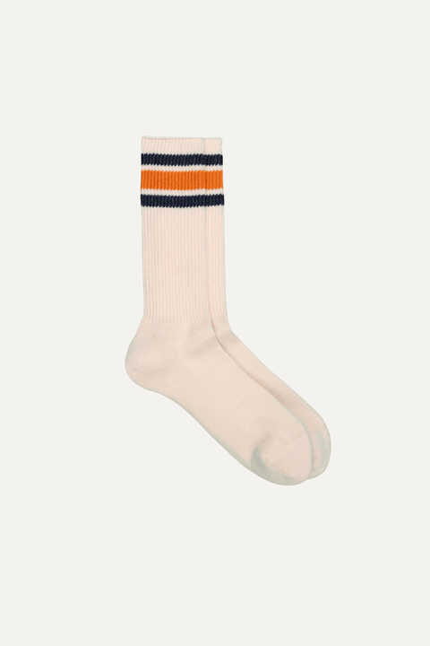A single cream-colored ribbed crew sock with two stripes near the cuff, featuring navy blue and orange, shown against a plain off-white background - Inkerman NYC